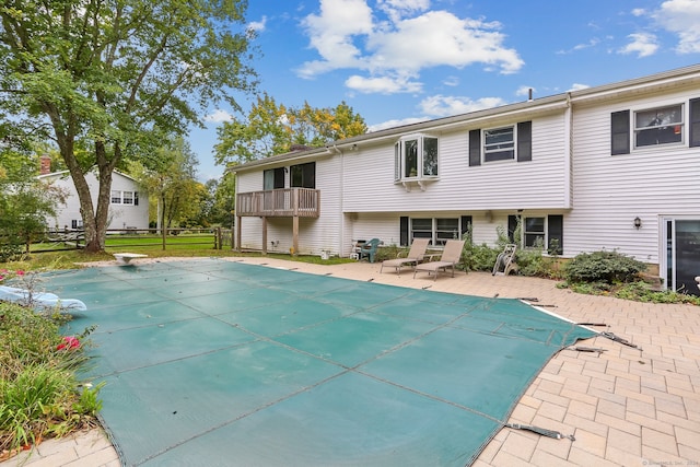 view of pool featuring a diving board, a lawn, and a patio area