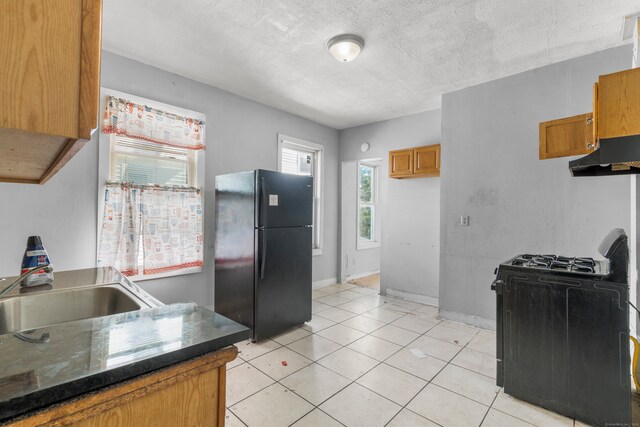 kitchen featuring light tile patterned flooring, sink, a textured ceiling, black appliances, and range hood