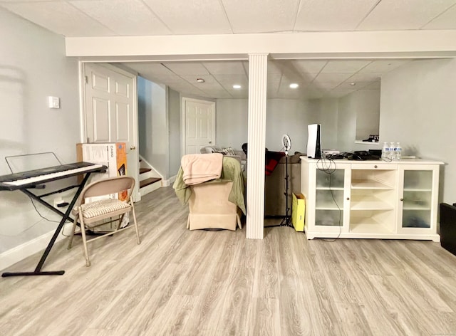 living area featuring a drop ceiling and light hardwood / wood-style floors