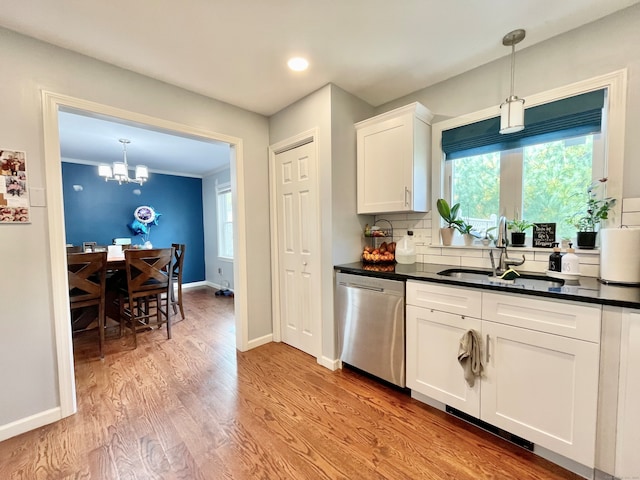 kitchen with stainless steel dishwasher, tasteful backsplash, white cabinets, light hardwood / wood-style flooring, and decorative light fixtures