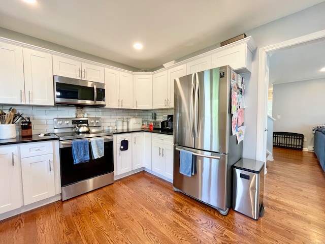 kitchen featuring appliances with stainless steel finishes, light wood-type flooring, and white cabinetry