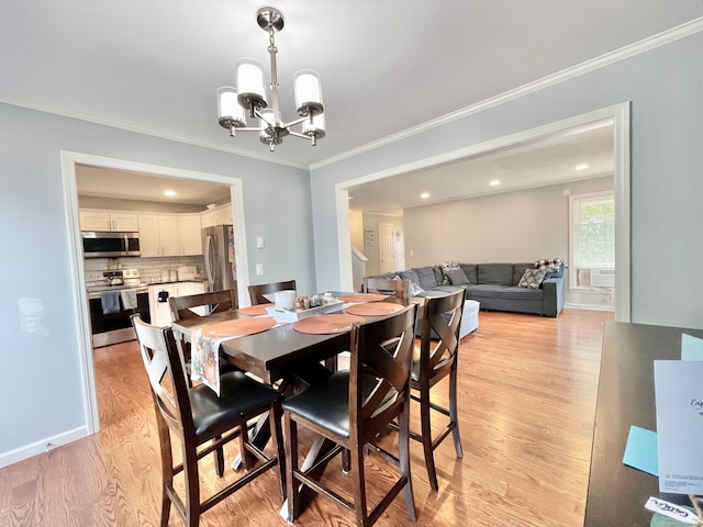 dining room with ornamental molding, a notable chandelier, and light wood-type flooring