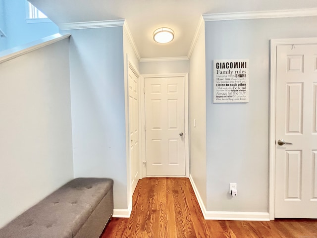 hall with wood-type flooring and ornamental molding