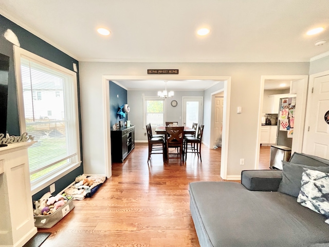 living room with an inviting chandelier, hardwood / wood-style flooring, and ornamental molding