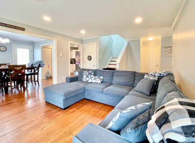 living room with light wood-type flooring and crown molding