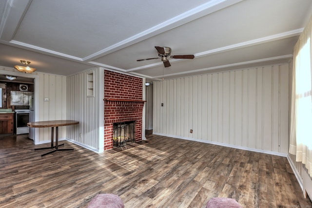 unfurnished living room featuring ceiling fan, wooden walls, a fireplace, and dark hardwood / wood-style floors