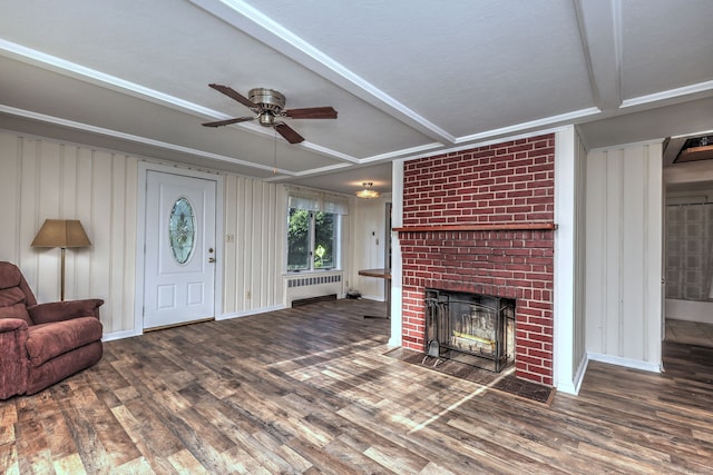 living room with dark hardwood / wood-style flooring, radiator heating unit, a brick fireplace, and ceiling fan