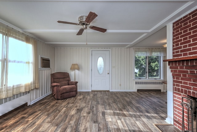 entrance foyer featuring dark wood-type flooring, wooden walls, a wall mounted air conditioner, radiator heating unit, and ceiling fan