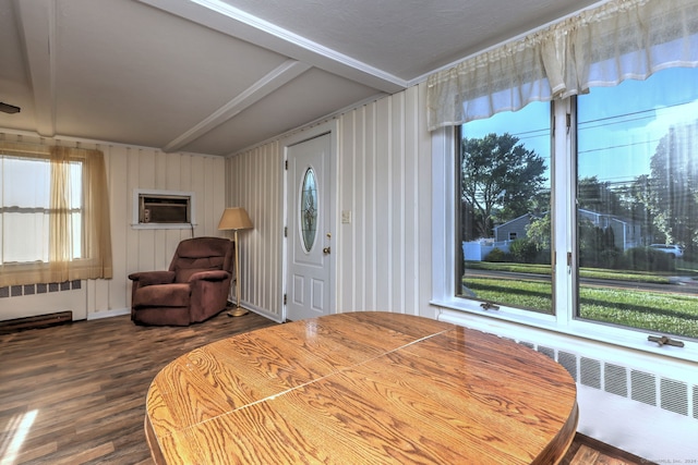 bedroom with wood-type flooring, radiator, and a wall mounted air conditioner