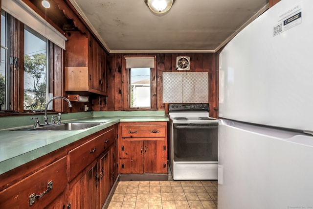 kitchen featuring wood walls, sink, and white appliances