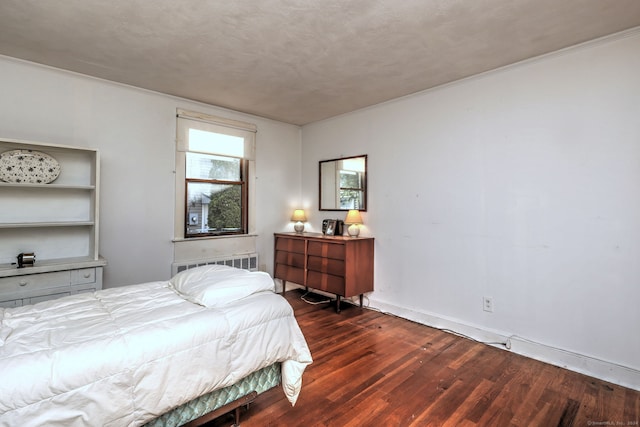 bedroom with a textured ceiling, dark hardwood / wood-style floors, and ornamental molding