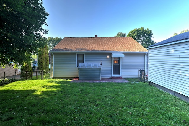 rear view of property with a lawn