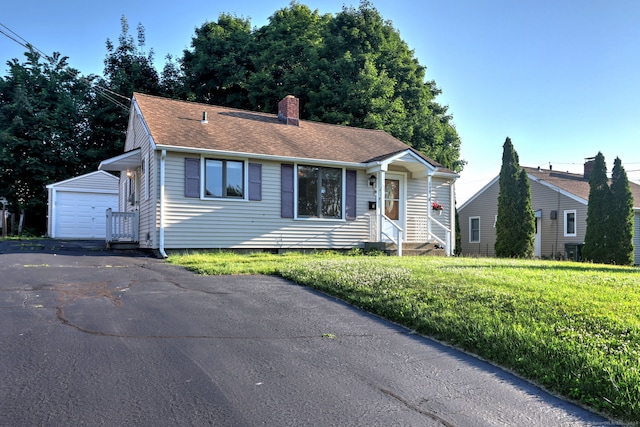 view of front facade with an outbuilding, a garage, and a front yard