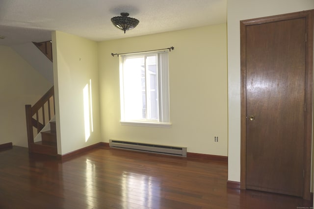 unfurnished room with a textured ceiling, baseboard heating, and dark wood-type flooring