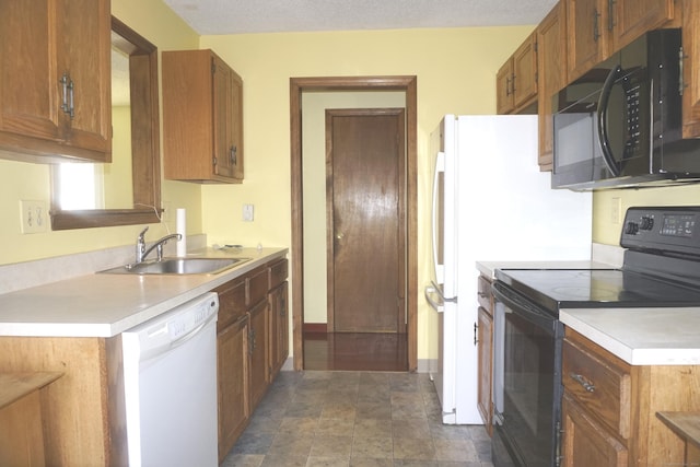 kitchen with black appliances, sink, and a textured ceiling