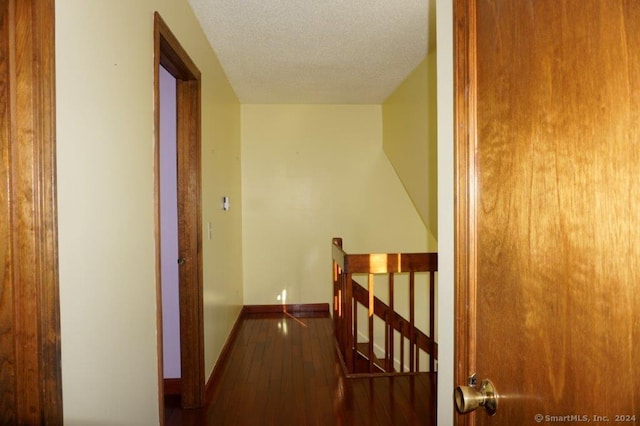 corridor featuring a textured ceiling and hardwood / wood-style flooring