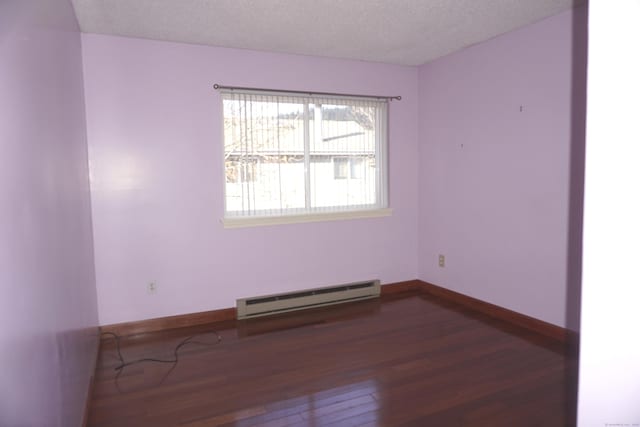 unfurnished room featuring wood-type flooring, a textured ceiling, and baseboard heating