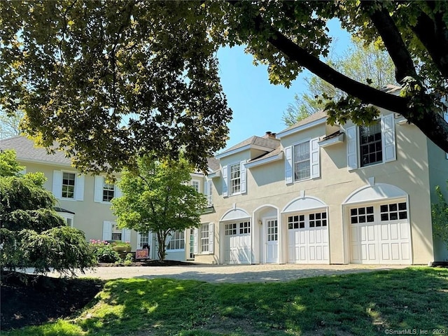 view of front of house featuring a garage and a front lawn