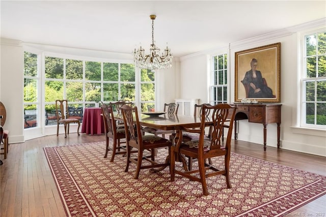 dining space featuring ornamental molding, hardwood / wood-style floors, a healthy amount of sunlight, and a chandelier