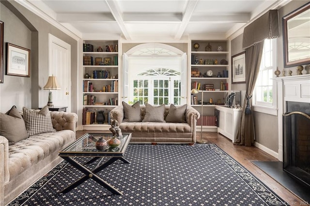 living room featuring beam ceiling, dark wood-type flooring, built in shelves, and coffered ceiling