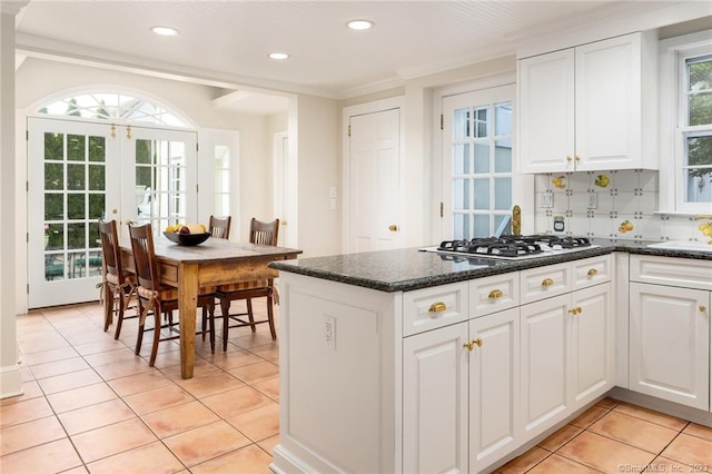 kitchen with white cabinetry, stainless steel gas stovetop, and tasteful backsplash