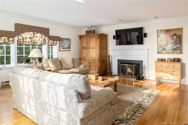 living room with ornamental molding, a baseboard heating unit, and light wood-type flooring