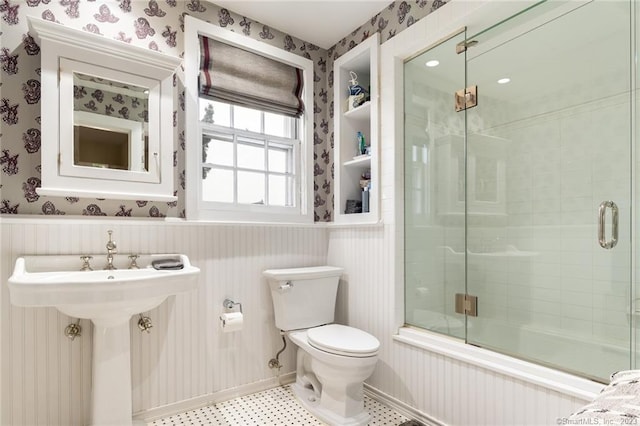 bathroom with shower / bath combination with glass door and toilet