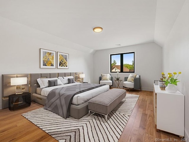 bedroom with hardwood / wood-style flooring and lofted ceiling