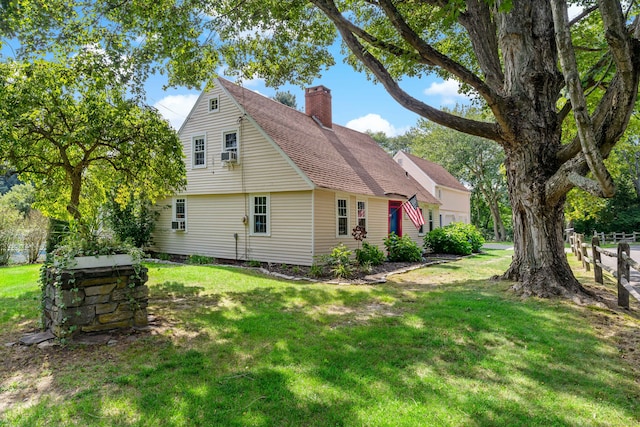 back of property featuring cooling unit and a yard