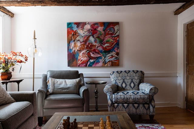 sitting room with beamed ceiling and hardwood / wood-style floors