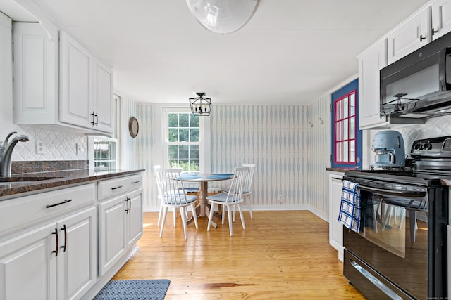 kitchen featuring white cabinets, sink, light hardwood / wood-style floors, and black appliances