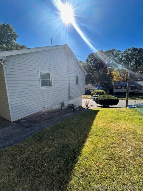 view of side of home with a yard