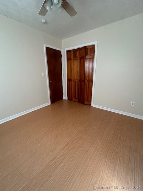 unfurnished bedroom with ceiling fan, a closet, and light hardwood / wood-style floors