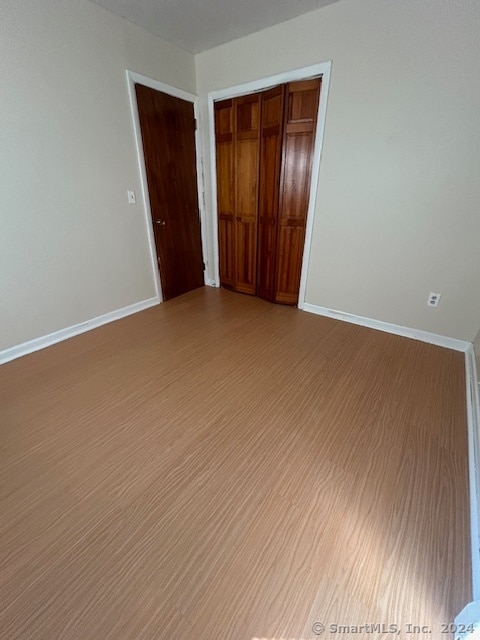 unfurnished bedroom with a closet and light hardwood / wood-style flooring