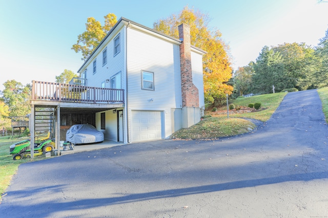 view of property exterior featuring a garage and a wooden deck