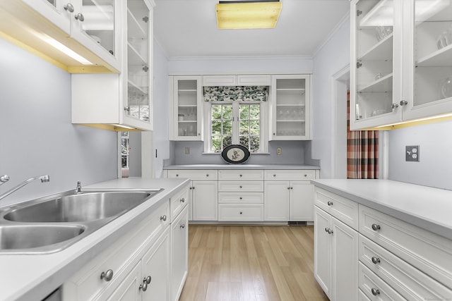 91 Open Gate Ln, Fairfield, CT 06890 - kitchen with a sink, white cabinets, light wood-type flooring, light countertops, and ornamental molding