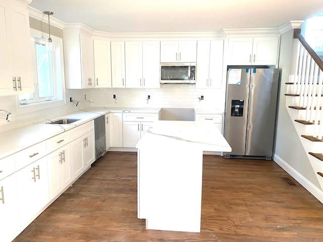 kitchen featuring dark wood-type flooring, hanging light fixtures, plenty of natural light, and appliances with stainless steel finishes