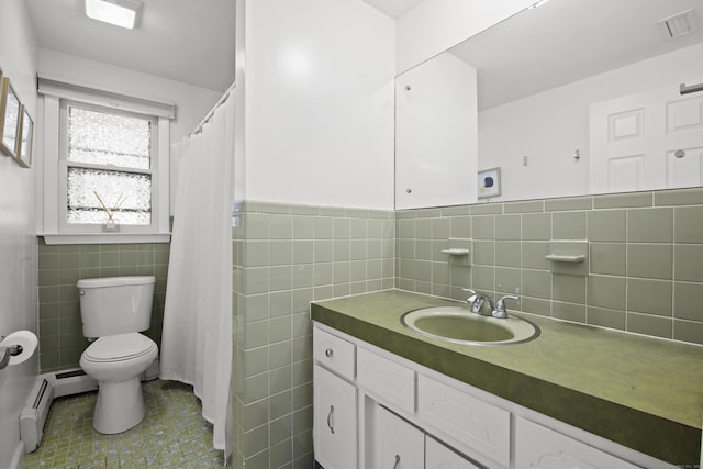 bathroom featuring a wainscoted wall, toilet, tile walls, baseboard heating, and vanity