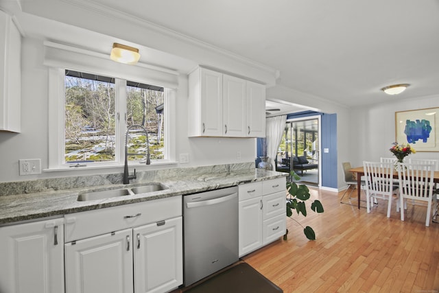 kitchen featuring dishwasher, light wood-type flooring, crown molding, and a sink