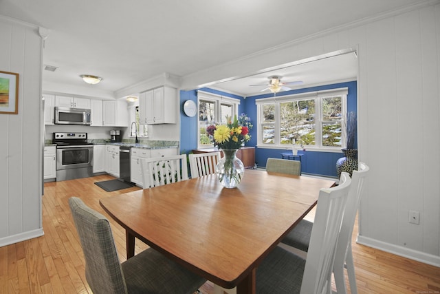 dining space featuring visible vents, ornamental molding, light wood-style floors, baseboards, and ceiling fan