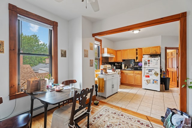 kitchen featuring white appliances, light wood-type flooring, light brown cabinetry, and ceiling fan