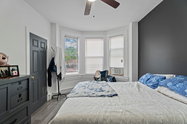 bedroom featuring cooling unit, ceiling fan, and light hardwood / wood-style floors