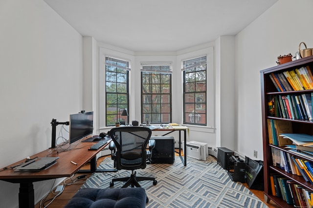 office space featuring light hardwood / wood-style flooring and a baseboard heating unit