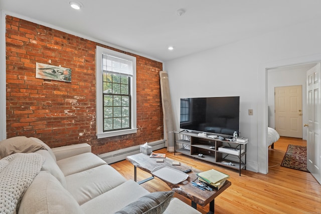 living room featuring brick wall, light hardwood / wood-style flooring, and a baseboard heating unit