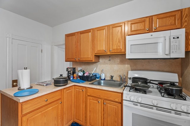 kitchen with kitchen peninsula, sink, and white appliances