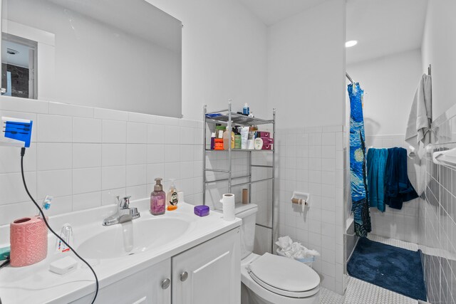 full bathroom featuring vanity, tile walls, shower / bathtub combination with curtain, tile patterned flooring, and toilet