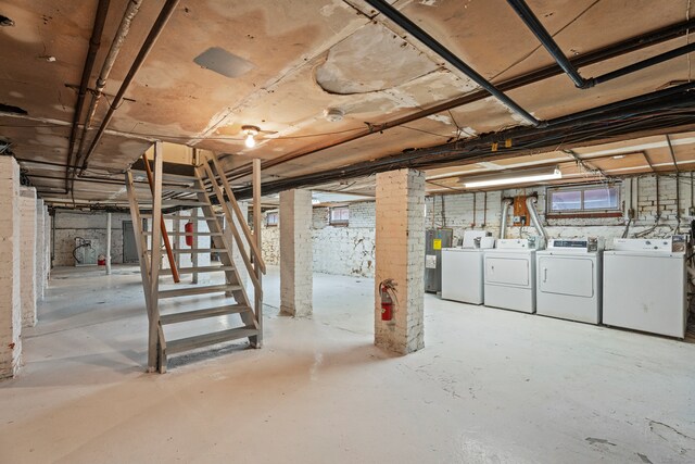 basement with washer and dryer and brick wall