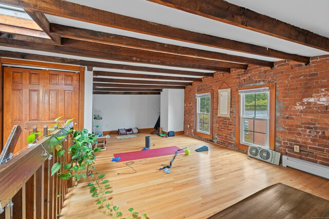 workout room featuring brick wall and hardwood / wood-style floors