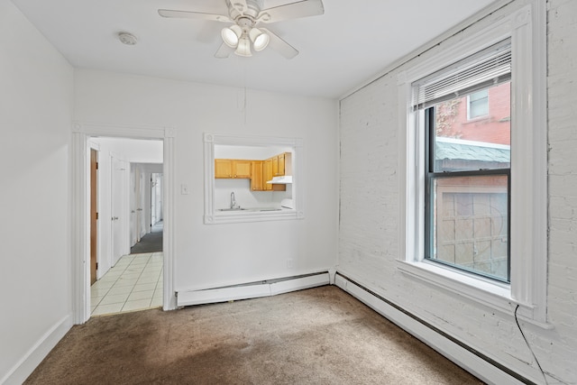 unfurnished room featuring sink, light colored carpet, a baseboard heating unit, and ceiling fan