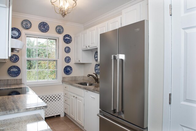 kitchen with light stone countertops, white cabinetry, high end refrigerator, and sink